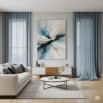 Modern living room featuring a large abstract wall art in blue and beige tones, perfectly harmonized with sheer blue curtains and minimalist decor.