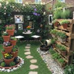 Small home garden with vertical planters, colorful flowers, cozy seating area, and decorative pathway creating a charming outdoor space.