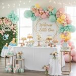 Baby shower dessert table with pastel balloon arch, floral decorations, and welcome sign 2025