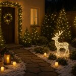 Warmly lit Christmas garden scene with LED reindeer sculpture, evergreen trees covered in fairy lights, candles along the pathway and holiday wreaths on the door and fence.